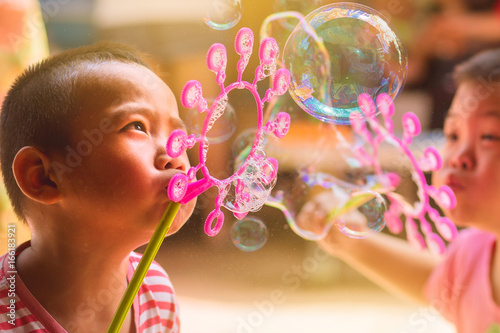 asian boys blowing soap bubbles.