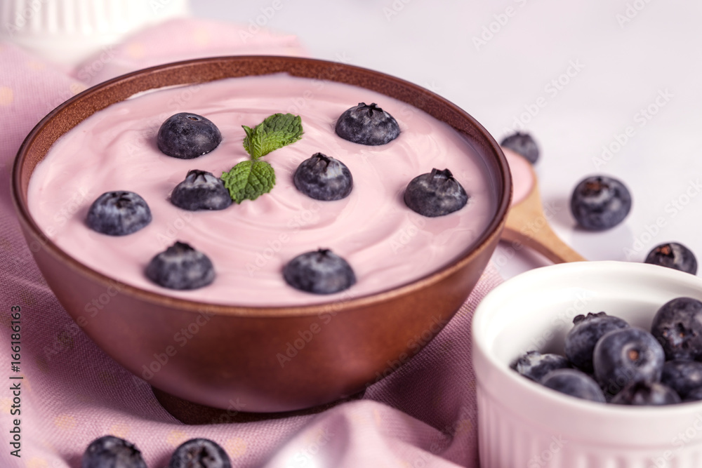 close up the pink creamy homemade blueberries fruit yogurt with fresh green mint leaf on wooden table background close up the pink creamy homemade blueberries fruit yogurt with fresh green mint leaf on wooden table background