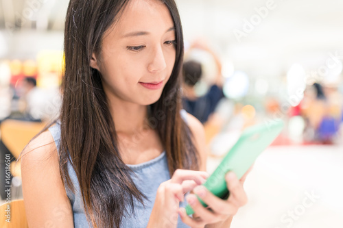 Young Woman using mobile phone in restaurant