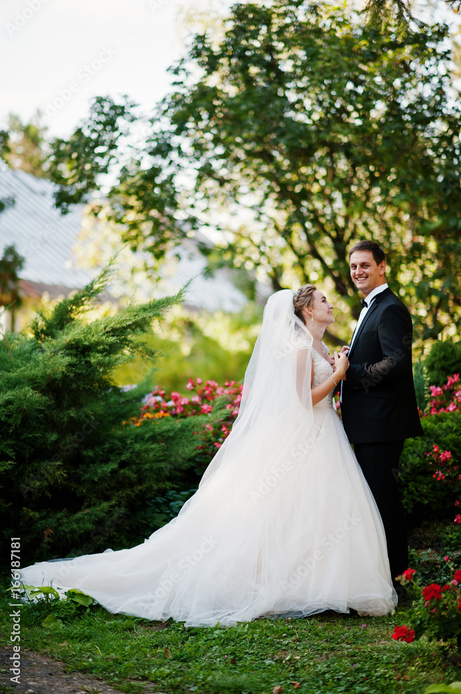 Beautiful couple walking in the park full of bright colorful flowers. Beautiful couple walking in the park full of bright colorful flowers.