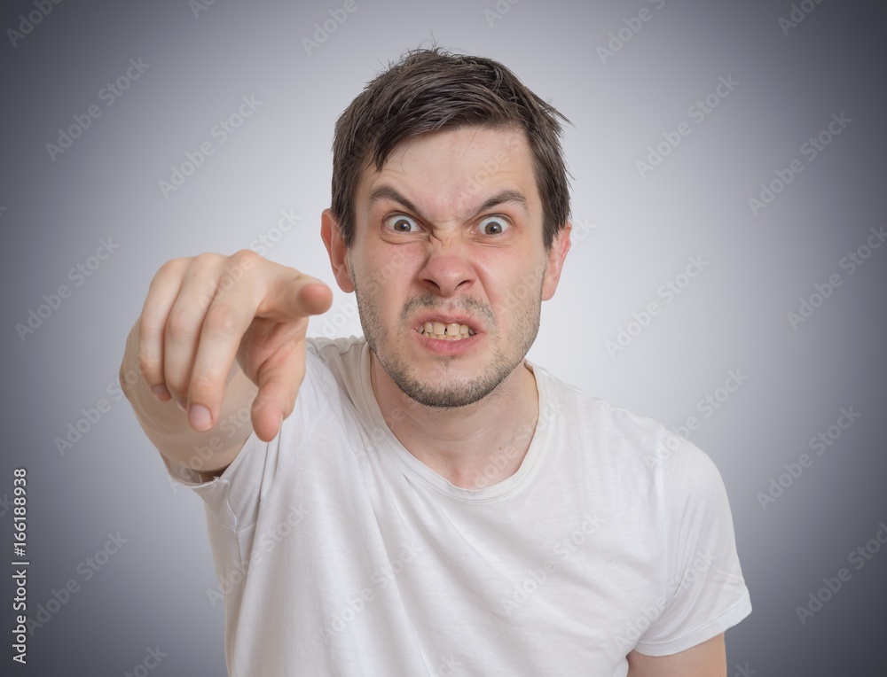 Angry young man is pointing towards you. Angry young man is pointing towards you.