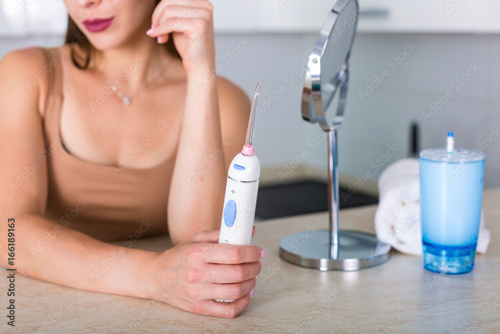 Woman with a toothbrush and an oral irrigator Woman with a toothbrush and an oral irrigator