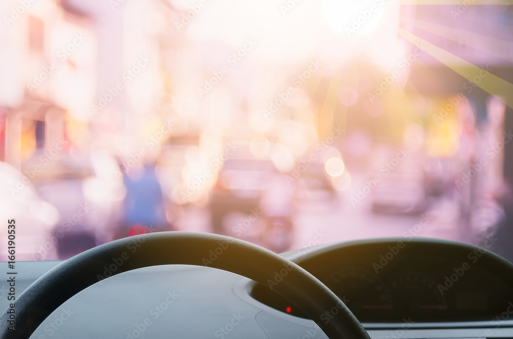 Inside car view ,steering wheel on blur traffic road with colorful bokeh light abstract background. Inside car view ,steering wheel on blur traffic road with colorful bokeh light abstract background.