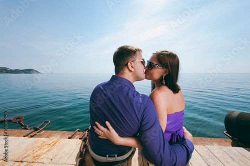 A loving couple in purple outfits on the seashore