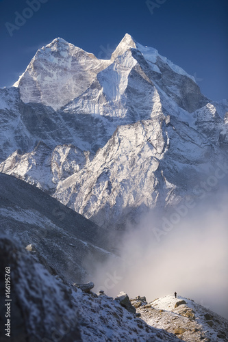 Man and mountains. Nepal, Everest Region, view of Kantega peak (6,782 m) from the hill near Pheriche village (4,371 m). photo