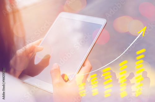 Business economic and technology working concept. Woman using smart phone on street double exposure graph money stock trading up trend arrow bar bokeh background.