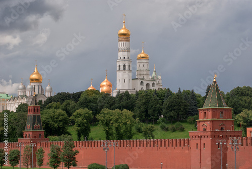 View on Archangelsky and Uspensky Cathedral behind the Kremlin wall in Moscow against the background of the cloudy sky photo