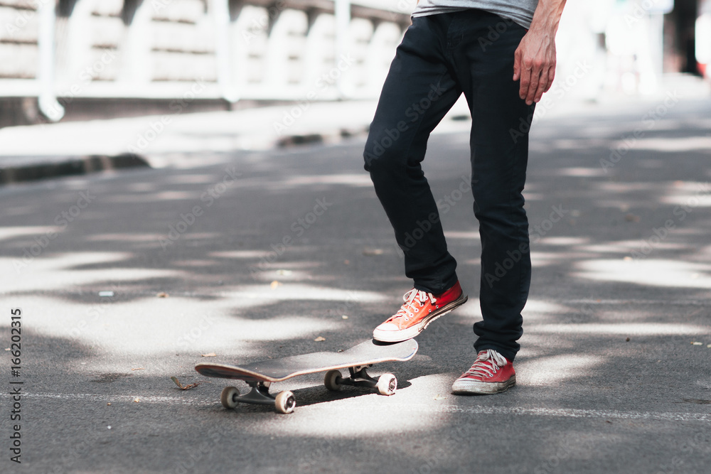 Fan active extreme urban sport fo young kid at city street. Unrecognizable skateboarder prepare for practice skateboard trick.