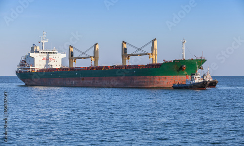 Bulk carrier and tug boats. Big cargo ship