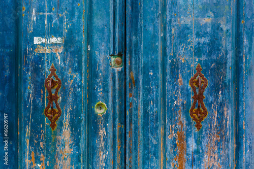 Texture blue cracked old door with iron rusty hooks photo