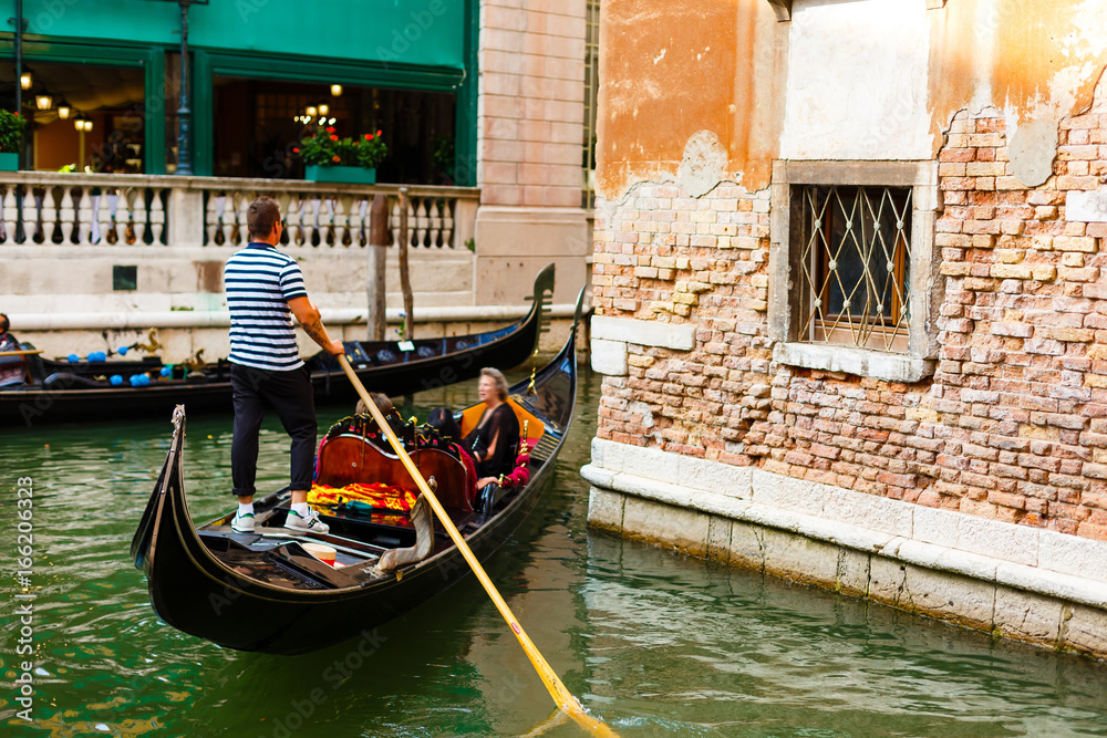 Venice, Italy - July 20 2017 : Gondolier with paddle in Venice. gondolier sail on a Venetian canal during the Carnival of Venice. man in his gondola on the Grand Canal, Italy
