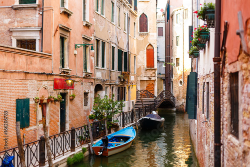 Narrow canal with boats in Venice, Italy