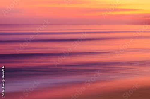 Fototapeta Naklejka Na Ścianę i Meble -  Motion blur tropical sunset beach with bokeh sun light wave abstract background.