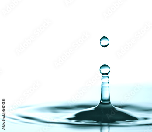 Water drop and splash on water surface on blue background