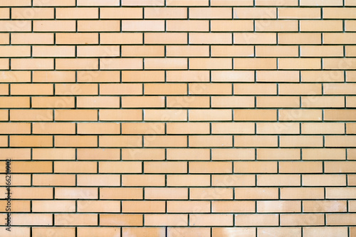 The texture of the brickwork. Horizontal frame.The smooth surface of the wall is made of light yellow ceramic bricks