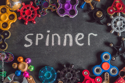 A lot of different spinners on a black background And the inscription spinner photo