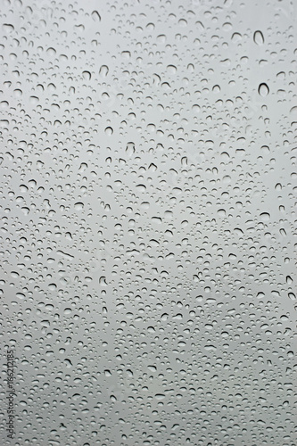 Rain drops on window glass. Abstract vertical background.