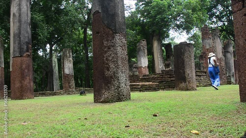 Travelers thai woman walking and visit ancient building and ruins of Kamphaeng Phet Historical Park is an archeological site and Aranyik Area in Kamphaeng Phet, Thailand photo