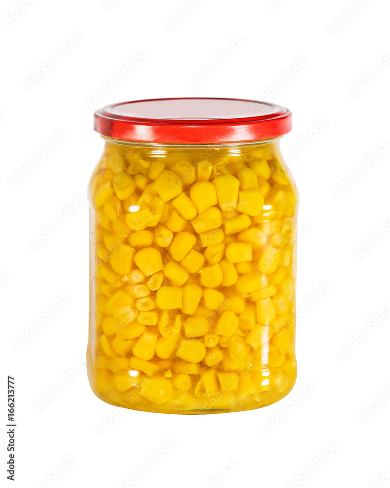 Marinated bright yellow grains of corn in a glass jar, isolated on white..