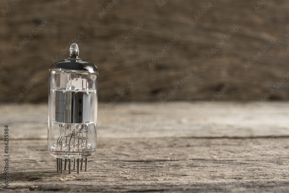 vacuum tube, old electronic component part on wooden surface and blur background vacuum tube, old electronic component part on wooden surface and blur background
