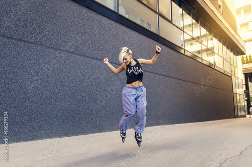 Cool young hipster woman enjoying, jumping with roller skates