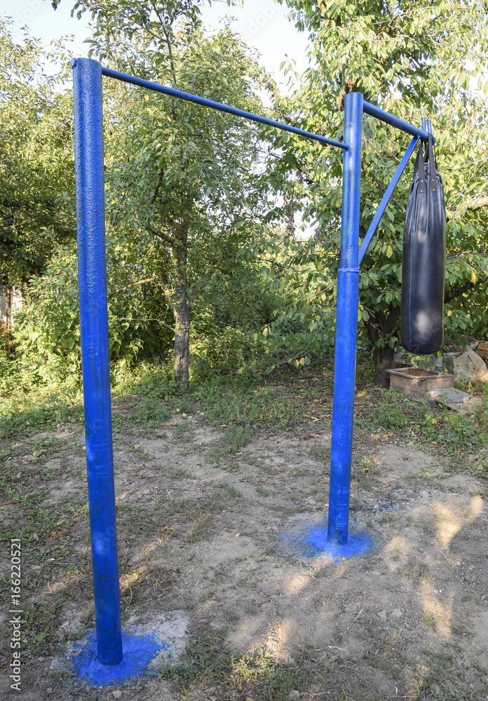 Homemade bar with a punching bag outdoors in the garden. Homemade bar with a punching bag outdoors in the garden.