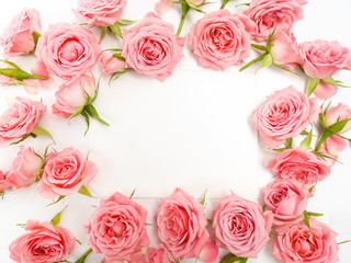 Framework from roses on white background. Flat lay, top view