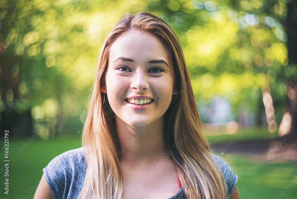 Portrait of a happy young woman outside on a bright summer day Portrait of a happy young woman outside on a bright summer day