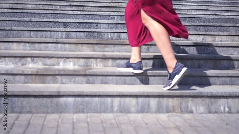 Girl in sneakers and dress climbs the stairs upwards. HD, 1920x1080. Slow motion Girl in sneakers and dress climbs the stairs upwards. HD, 1920x1080. Slow motion