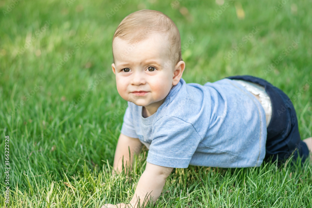 Crawling cute baby boy on green grass outdoor at summer Crawling cute baby boy on green grass outdoor at summer