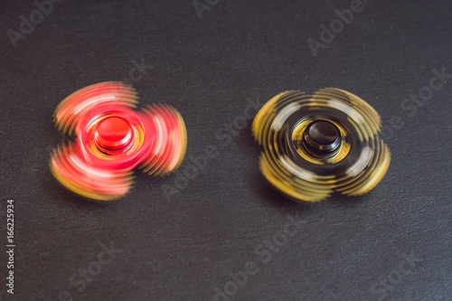 Famous fidget spinner stress relieving n a black wooden background photo