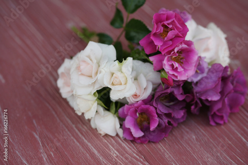 Bouquet of pink and purple garden roses on a wooden background