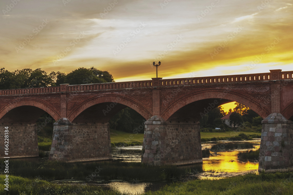 Fototapeta premium The old-fashioned Latvia.Kuldiga. ventas hub over the bridge at night