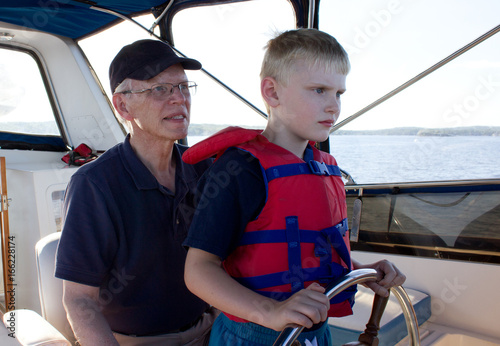 a serious child learns sailing from his grandfather