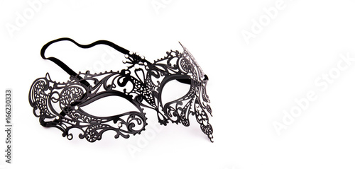 Black delicate lace mask on a white background. Black metal carnival mask. Copy space