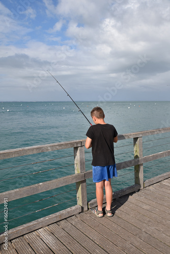 Jeune pêcheur à la ligne en été