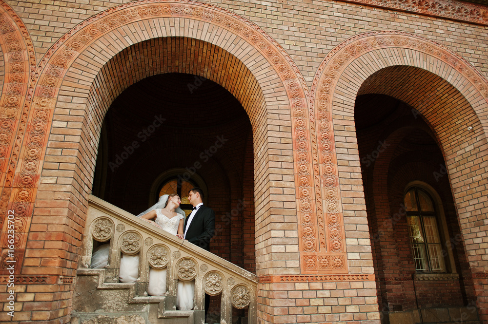 Stunning wedding couple enjoying each other's company on a beautiful architectural background.