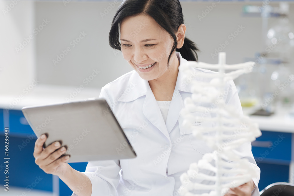 Joyful positive woman looking at the tablet screen Joyful positive woman looking at the tablet screen