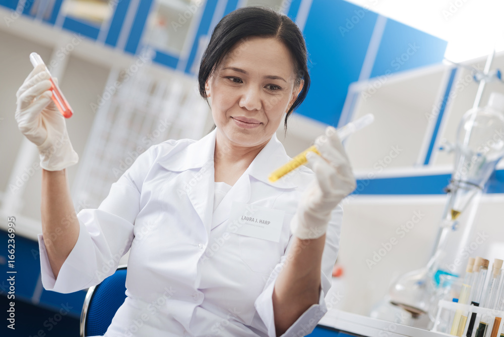 Pleasant female scientist using chemical reagents Pleasant female scientist using chemical reagents
