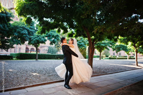 Fantastic wedding couple walking in the park on their wedding day.