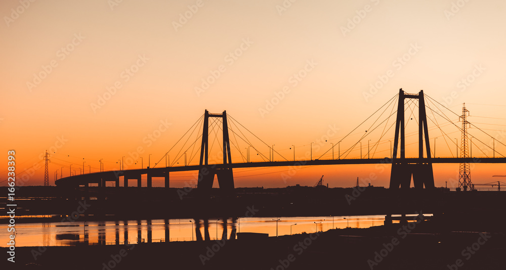 Silhouette of the suspension concrete bridge on a sunset