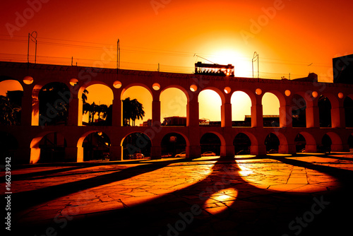 Spectacular View of Iconic Santa Teresa Tram Driving Along the Carioca Aqueduct by Sunset in Rio de Janeiro City Downtown, Brazil