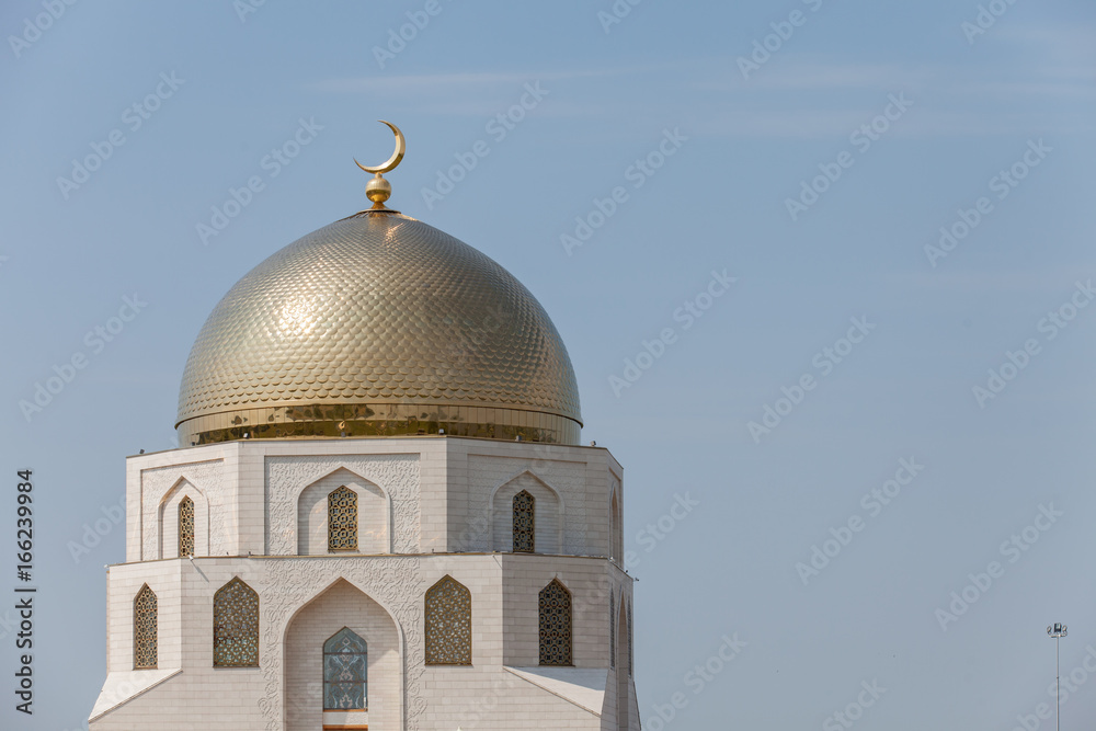 Beautiful mosque, golden shine minarets, against the blue sky