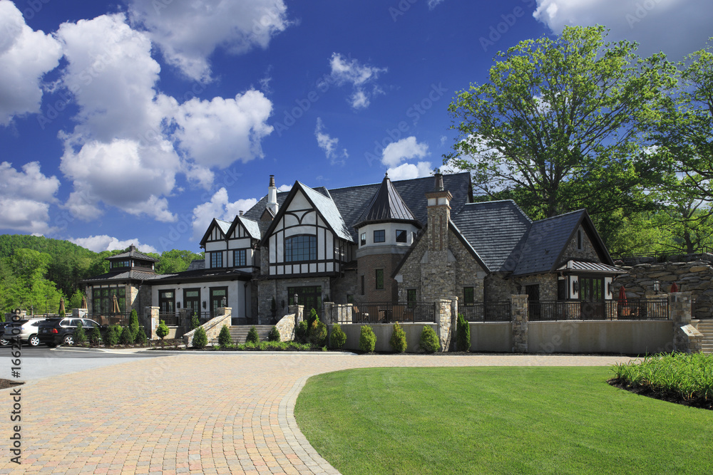 Huge Luxurious expensive farmhouse style mansion with long brick driveway,  stone walls, and large patio Stock Photo | Adobe Stock