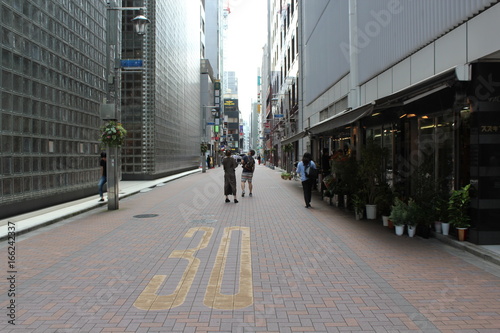 People walking on the street in tokyo near to maison hermes by renzo piano architecture photo