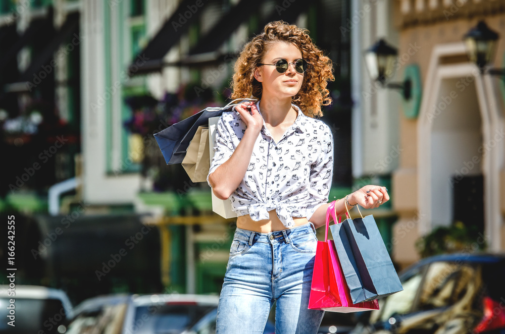 Young beautiful girl is strolling after shopping.