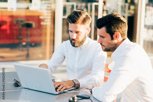 two bearded business men young outdoor using computer - remote working, business, finance concept