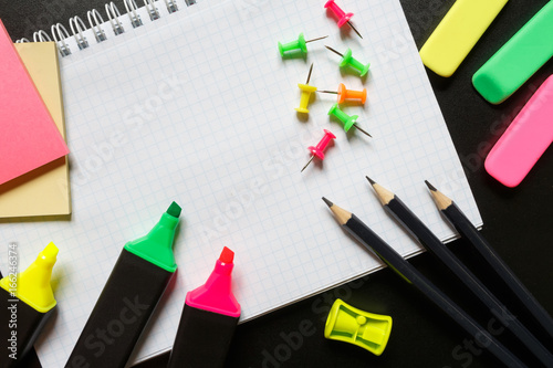 School accessories marker, pencil, scissors, eraser, paper clips, paper, brush on a dark background with copy space. Concept back to school