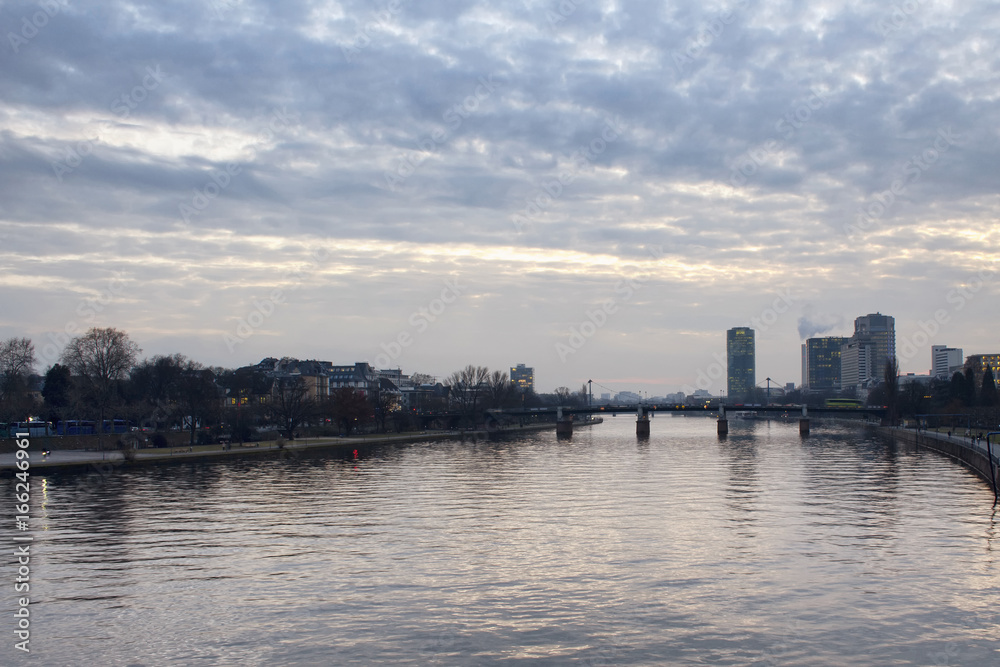 View of main river and cityscape of Frankfurt at dusk.
