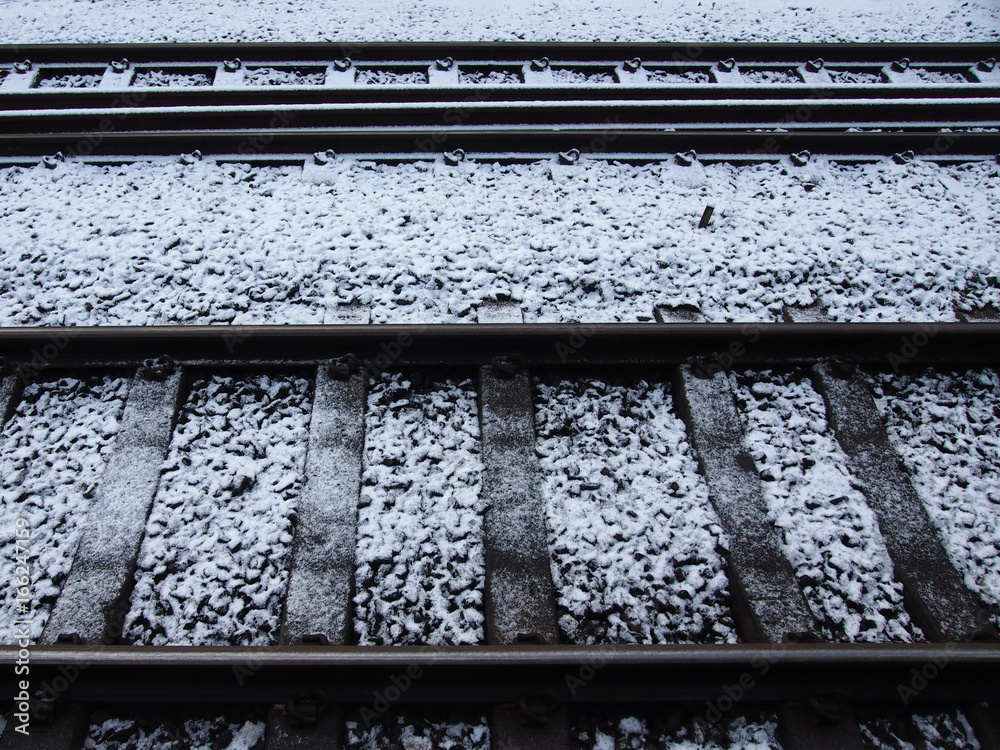 snow and frost on railway tracks in winter running in parallel lines